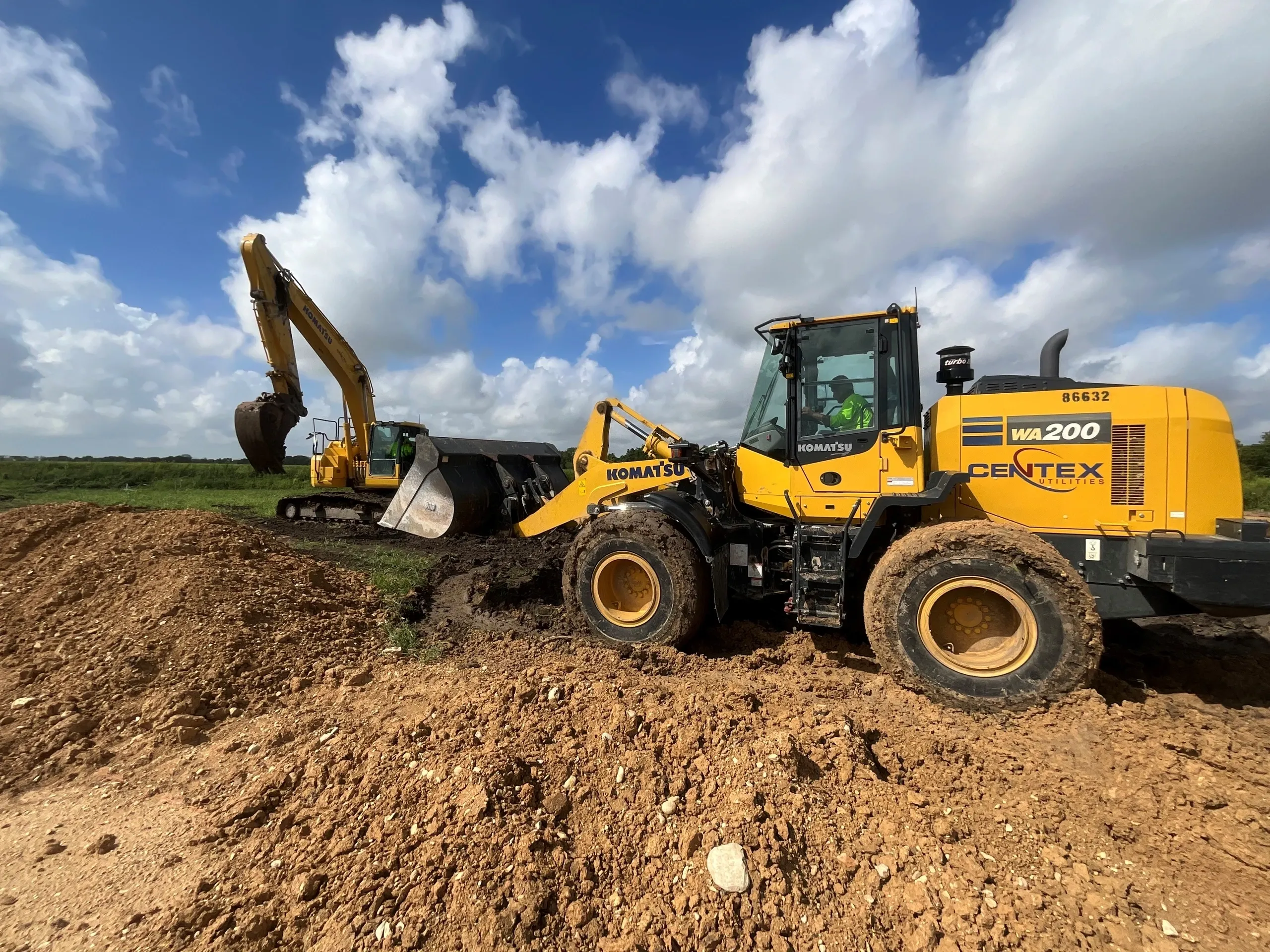 A yellow and black tractor is on the dirt