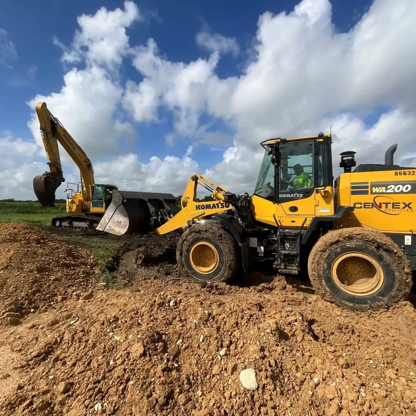 A yellow and black tractor is on the dirt